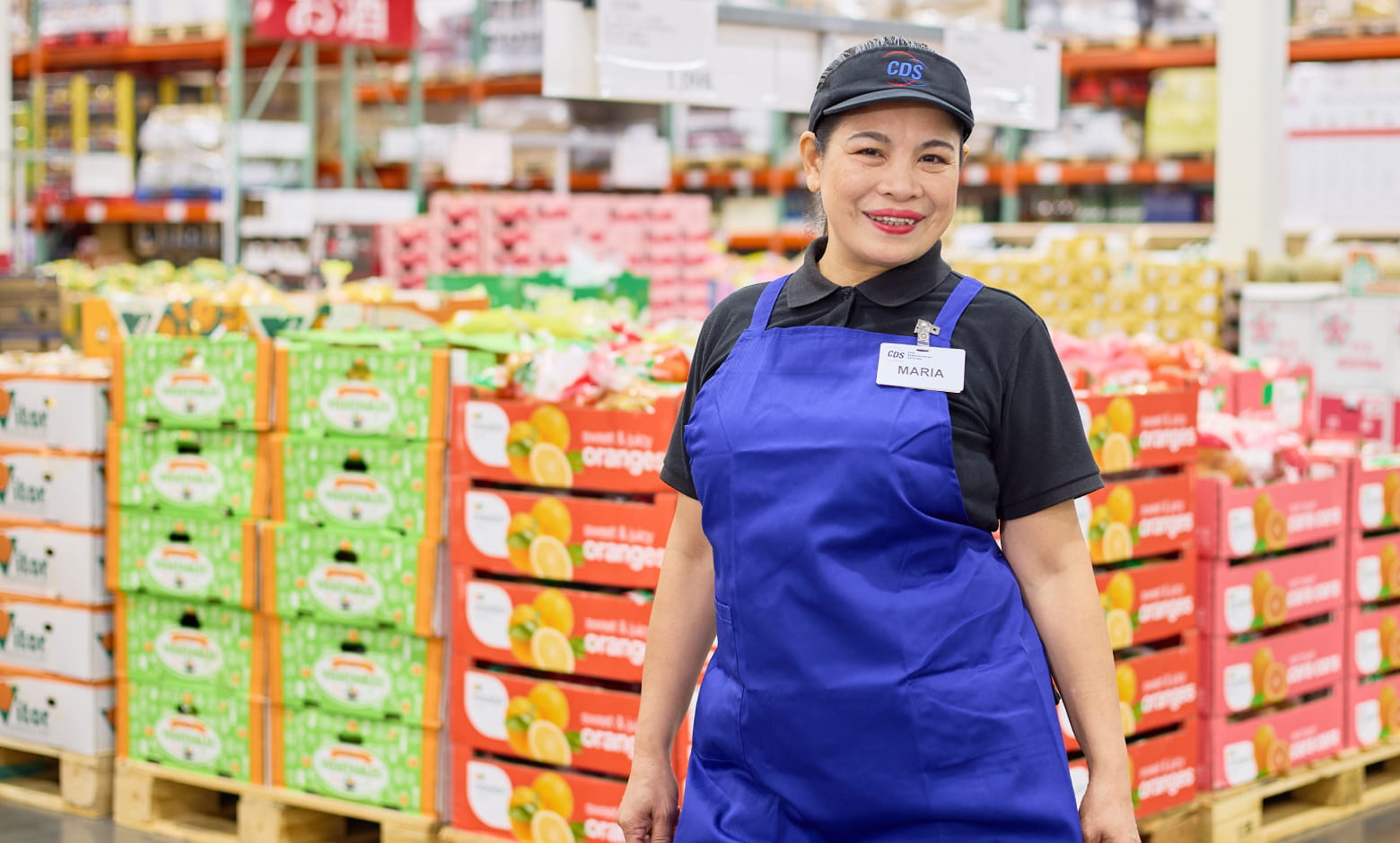 コストコ倉庫店の青果売り場に立つ販売スタッフのMARIAさん